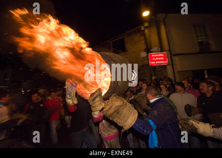 Grand men's barrel en cours au travers des foules sur la place pour marquer le Bonfire Night, 5 novembre, à la tar de barils festival, Honiton, Devon, Angleterre Banque D'Images