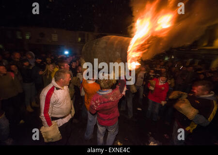 Grand men's barrel en cours au travers des foules sur la place pour marquer le Bonfire Night, 5 novembre, à la tar de barils festival, Honiton, Devon, Angleterre Banque D'Images