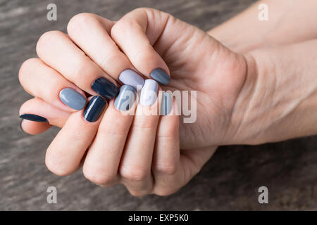 De belles mains avec la miniature peinte dans une couleur gris Banque D'Images