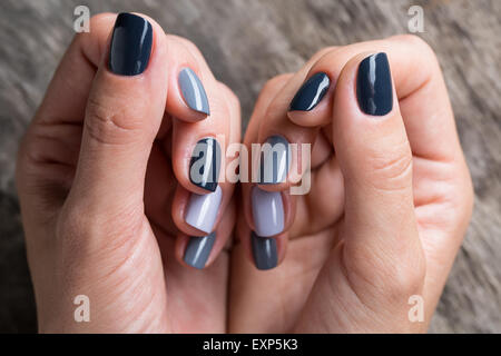 De belles mains avec la miniature peinte dans une couleur gris Banque D'Images