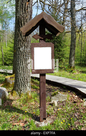 Sentier de bois l'énergie solaire dans le bois peut. Le babillard et une direction signe sont faites de vieux chêne. Zone vide w isolés Banque D'Images