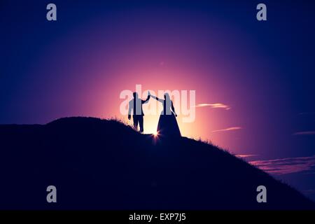 Vintage photo de silhouettes de wedding couple photographié dans l'air extérieur. Beaux jeunes gens dans leur jour de mariage Banque D'Images