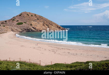 Une femme seule à bronzer sur le sable blanc pur de Cala Mesquida Beach sur l'île de Minorque espagne Banque D'Images