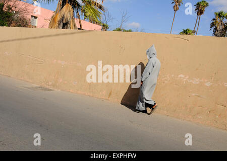 L'homme à marcher le long de la hotte mur à Taroudant. Banque D'Images