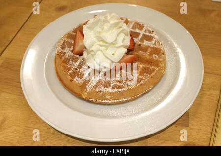 Gaufre avec de la crème chantilly, fraise et cerise Banque D'Images