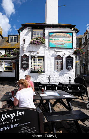 St Ives, Cornwall, UK : Couple assis dehors le sloop Inn à St Ives avec un verre et regarder spéciaux Banque D'Images