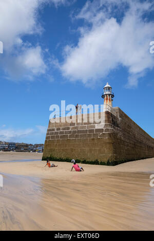 St Ives, Cornwall, UK : Couple pose pour la photo sur la plage à la fin de Smeaton's Pier à St Ives Cornwall. Banque D'Images