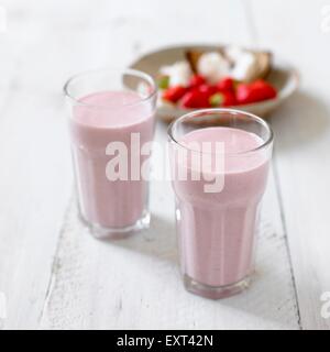 Deux verres de fraise et des smoothies, macadamia ingrédients dans l'arrière-plan Banque D'Images