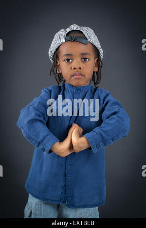 Beau garçon faisant des expressions différentes dans différents ensembles de vêtements : la prière Banque D'Images