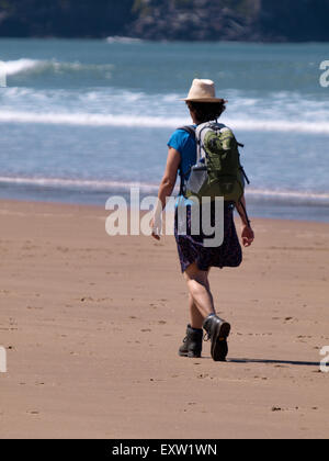 Female hiker sur la plage, Woolacombe, Devon, UK Banque D'Images