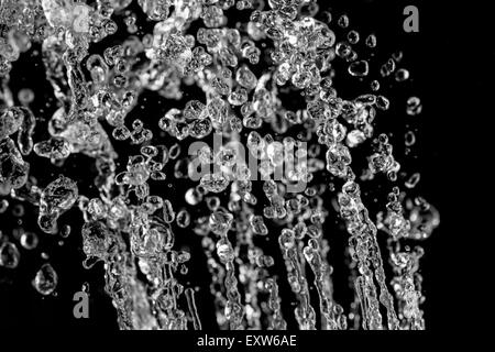 Léviter des gouttes d'eau sur fond noir. Les éclaboussures d'eau sur fond sombre. Banque D'Images