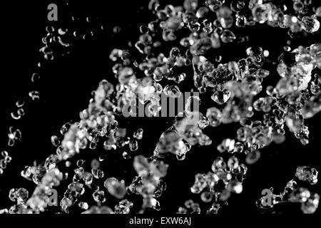 Les gouttes d'eau en lévitation. Jet de l'eau survolez sur fond noir. Concept Spa. Banque D'Images