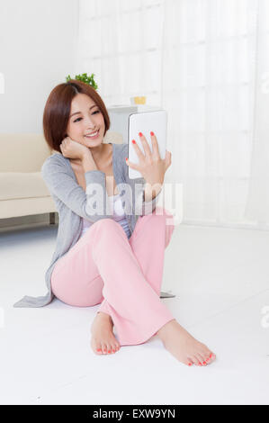 Jeune femme assise sur le sol et sur le bloc de touches avec sourire, Banque D'Images