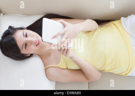 Young woman holding et pavé tactile avec sourire, Banque D'Images