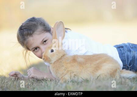 Fille avec son lapin sur pré, Haut-Palatinat, Bavaria, Germany, Europe Banque D'Images