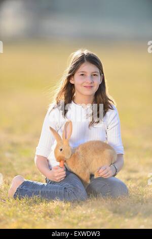 Adolescente avec son lapin sur un pré, Haut-Palatinat, Bavaria, Germany, Europe Banque D'Images