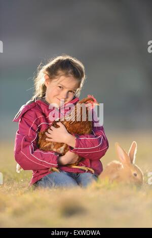 Fille avec son lapin et un poulet sur un pré, Haut-Palatinat, Bavaria, Germany, Europe Banque D'Images