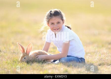 Fille avec son lapin sur pré, Haut-Palatinat, Bavaria, Germany, Europe Banque D'Images