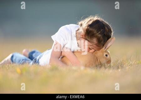 Fille avec son lapin sur pré, Haut-Palatinat, Bavaria, Germany, Europe Banque D'Images