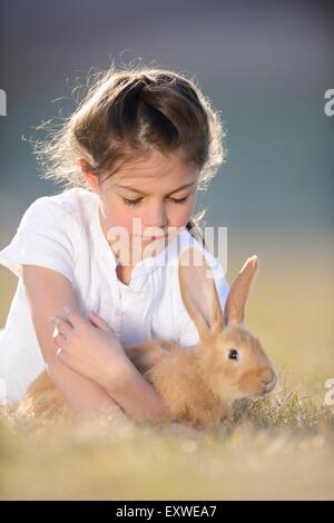 Fille avec son lapin sur pré, Haut-Palatinat, Bavaria, Germany, Europe Banque D'Images