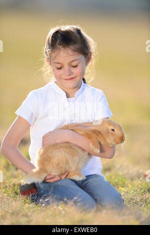 Fille avec son lapin sur pré, Haut-Palatinat, Bavaria, Germany, Europe Banque D'Images