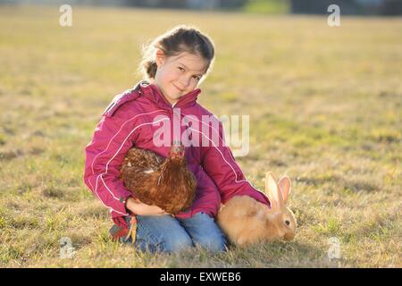 Fille avec son lapin et un poulet sur un pré, Haut-Palatinat, Bavaria, Germany, Europe Banque D'Images