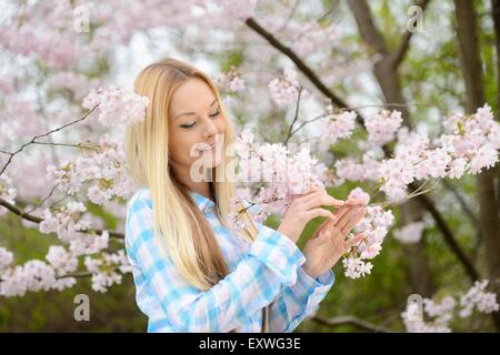 Jeune femme blonde dans un parc au printemps Banque D'Images