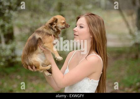 Jeune femme avec un dog puppy in garden Banque D'Images