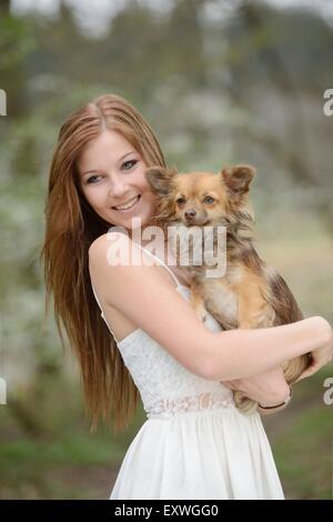 Jeune femme avec un dog puppy in garden Banque D'Images