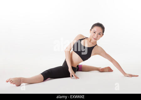 Woman practicing yoga avec jambes se divise, Banque D'Images