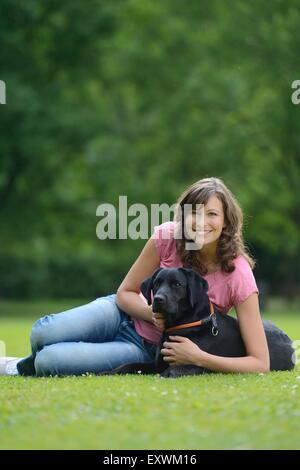 Femme avec un labrador noir sur un pré, Bavaria, Germany, Europe Banque D'Images