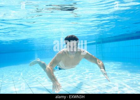 L'homme nage sous l'eau dans une baignoire en plein air Banque D'Images