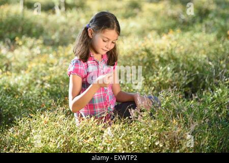 Girl eating berries dans une forêt de pins Banque D'Images