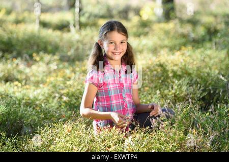 Girl eating berries dans une forêt de pins Banque D'Images