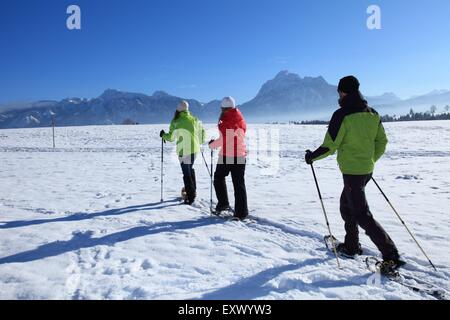 Trois personnes avec des raquettes, Tegelberg, Alpes, Allgaeu, Bavaria, Germany, Europe Banque D'Images