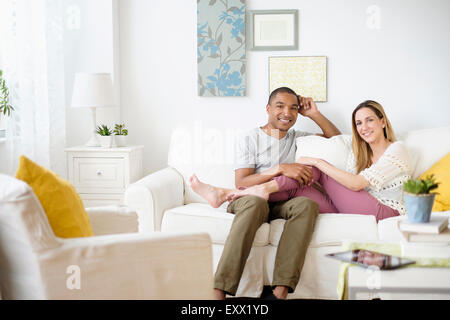 Young couple relaxing in living room Banque D'Images