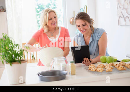 Mère avec sa fille adulte baking in kitchen Banque D'Images