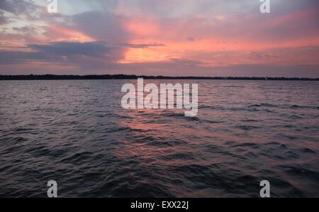 La surface du lac magnifique vu d'un yacht. Scène paisible coucher du soleil avec ciel nuageux au-dessus du lac de surface. Banque D'Images