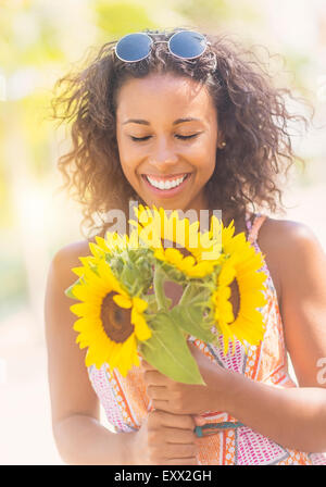 Portrait of smiling woman with sunflowers Banque D'Images