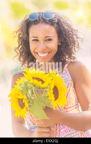 Portrait of smiling woman with sunflowers Banque D'Images