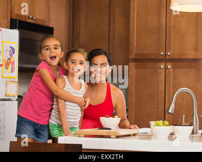 Mère et enfants (6-7, 8-9) preparing food in kitchen Banque D'Images