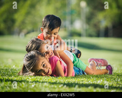 Enfants (2-3, 6-7, 8-9) playing in park Banque D'Images