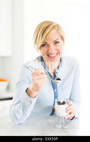 Portrait of woman eating yoghurt avec mûres Banque D'Images