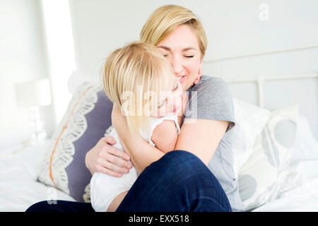 Woman hugging daughter (2-3) dans la chambre Banque D'Images