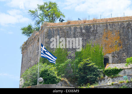 Waving Flag de la Grèce en face de la forteresse médiévale contre mur nuageux ciel bleu Banque D'Images