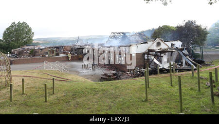 Lac, Isle of Wight, Hampshire, Royaume-Uni. Vendredi 17 Juillet, 2015. GV montrant la lumière du jour a clairement fait la destruction provoquée par un grand incendie qui a détruit une école dans le lac ce matin (vendredi). Cinquante équipes de pompiers de partout dans l'île ont été la lutte contre un incendie au centre de formation de l'île sur Manor Road, Lake depuis minuit une fois qu'il apparaît un mini-bus la propagation du feu à l'école. L'ancien Broadlea école primaire a été complètement détruit. Credit : uknip/ Alamy Live News Banque D'Images