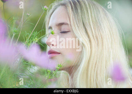 Woman smelling flowers Banque D'Images