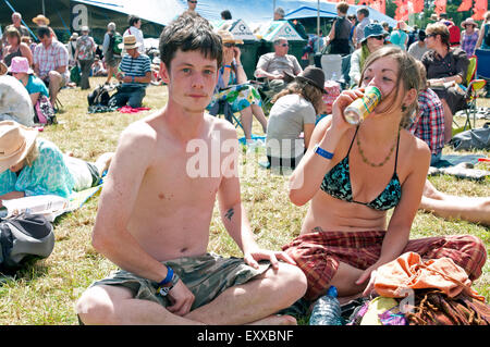 Deux jeunes hippies assis jambes croisées parmi la foule lors de la world music festival WOMAD Banque D'Images