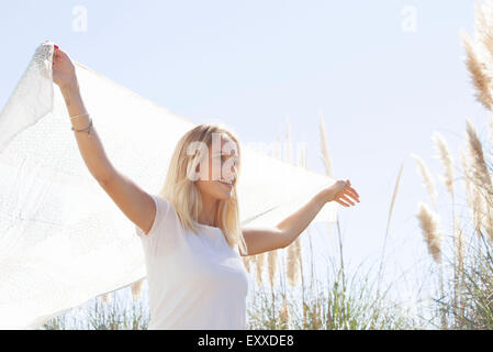 Woman holding up foulard voltigeant dans le vent Banque D'Images