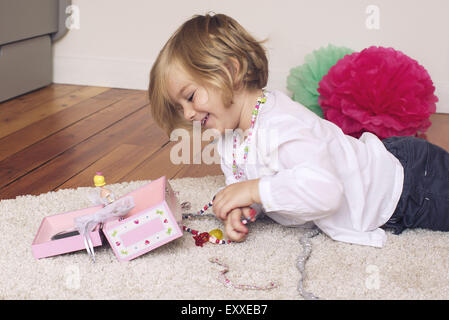 Petite fille de la dépose de la boîte de bijoux collier Banque D'Images